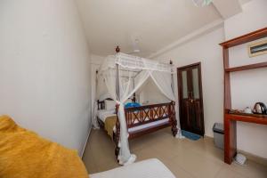 ein Schlafzimmer mit einem Himmelbett in einem Zimmer in der Unterkunft The Waves Unawatuna in Unawatuna