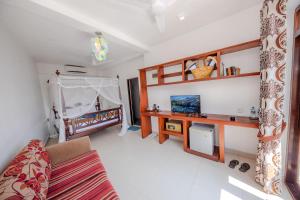 a living room with a couch and a tv at The Waves Unawatuna in Unawatuna