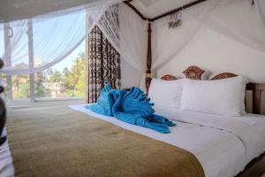 a bedroom with a bed with blue gloves on it at The Waves Unawatuna in Unawatuna