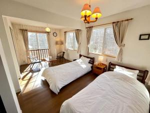 1 dormitorio con 2 camas y 1 dormitorio con ventanas en 八ヶ岳エンゼル #Ag1, en Hokuto
