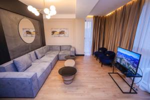 a living room with a couch and a flat screen tv at Arium Hotel Baku in Baku