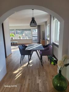a dining room with a table and chairs and a room with a table at Modernes Ferienappartement An der Steige in Wilhermsdorf