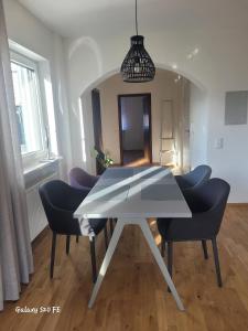 einen Esstisch und Stühle im Wohnzimmer in der Unterkunft Modernes Ferienappartement An der Steige in Wilhermsdorf