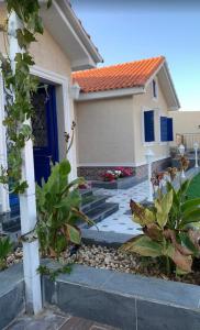 a house with a blue door and some plants at شاليه القمر في بهر in Ar Rawḑah