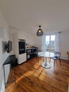 a living room with a table and chairs and a kitchen at Villa St-Gau in Saint-Gaudens