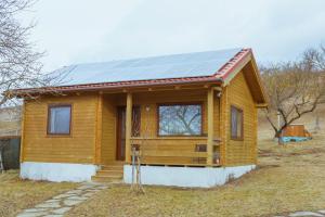 una pequeña casa con un panel solar en el techo en Country Garden - Országkert, en Păuleni-Ciuc