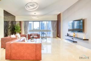 uma sala de estar com um sofá e uma televisão em Spacious 3BR with Assistant’s Room at West Heights 4 Business Bay by Deluxe Holiday Homes no Dubai