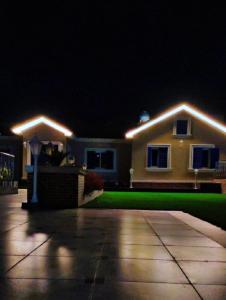 a house with lights on the front of it at night at شاليه الشروق in Ash Shuqra