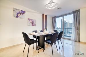 a dining room with a black table and chairs at Spacious 3BR with Assistant’s Room at West Heights 4 Business Bay by Deluxe Holiday Homes in Dubai