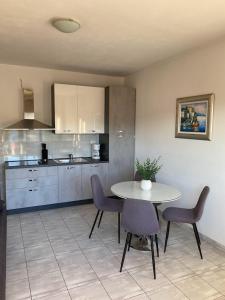 a kitchen with a table and chairs in a room at Apartment Kate in Trogir