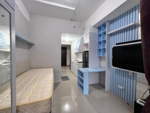 ein Wohnzimmer mit einem TV und einem blauen Regal in der Unterkunft Transpark Juanda by Bonzela Property in Padurenan