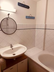 a bathroom with a sink and a tub and a mirror at Studio cosy quartier historique in Noirmoutier-en-l'lle