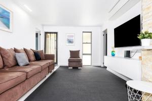 a living room with a brown couch and a tv at Broadwater Bay Villa in Broadwater +22 photos