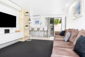 a living room with a couch and a flat screen tv at Broadwater Bay Villa in Broadwater
