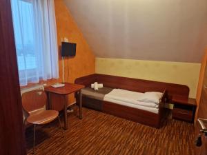 um pequeno quarto com uma cama e uma secretária em Motel Górno em Górno