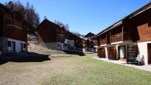 Una hilera de edificios de madera con césped delante de ellos. en Résidence Parc Aux Etoiles - CH17PAE - CHALET DUPLEX 2 CHAMBRE, TERRASSE ET BALCON MAE-2114, en Narreyroux