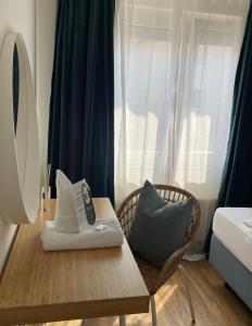 シュトゥットガルトにあるホテル ベルクのテーブル、椅子、ベッドが備わる客室です。