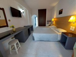 a hotel room with two beds and a desk at Oasis Hotel Bungalows Rhodes- All Inclusive in Afantou