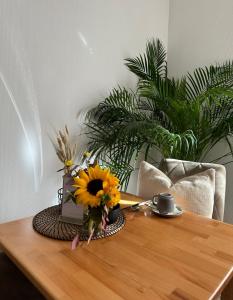 einen Tisch mit einer Vase Sonnenblumen drauf in der Unterkunft Hotel Berg in Stuttgart
