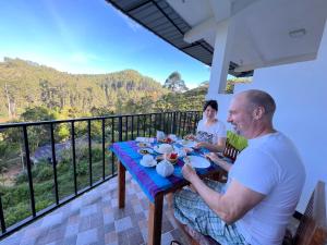 a man and woman sitting at a table on a balcony at Ella Silloam in Ella