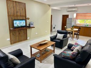 a living room with two couches and a television at The Seaboards Apartments Seychelles in Mahe