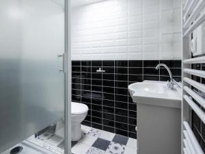 Baño en blanco y negro con aseo y lavamanos en Le Paris Eiffel - Appartement Cosy en plein centre, en Bourgoin