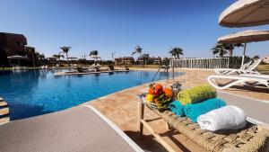 una mesa con juguetes junto a una piscina en Prestigia,Golf, piscine, soleil, paysage, sport, spacieux,lux résidence en Marrakech