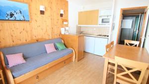 un soggiorno con un divano blu e una cucina di Résidence Parc Aux Etoiles - C310PAE - APPARTEMENT 2 CHAMBRES AVEC BALCON MAE-8774 a Narreyroux