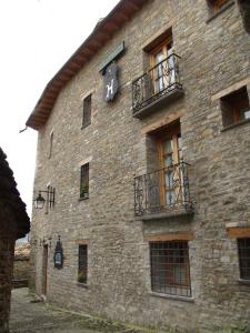 ein großes Steingebäude mit Fenstern und einem Balkon in der Unterkunft Hotel Posada Real in Aínsa