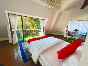 una camera da letto con un grande letto con cuscini rossi di Brookside Villa Pokhara a Pokhara