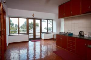 a kitchen with red cabinets and a large window at Brookside Villa Pokhara in Pokhara