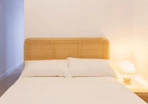 Bett mit einem Kopfteil aus Holz in einem Schlafzimmer in der Unterkunft Apartamento en Colón - Logroño in Logroño