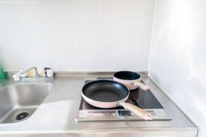 a pan sitting on top of a stove in a kitchen at Nishinippori Guest House in Tokyo