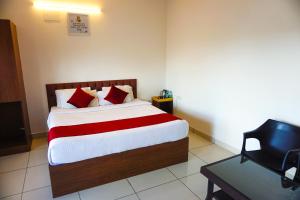 a bedroom with a bed with red and white pillows at Vistar Resort & Hotels in Bangalore