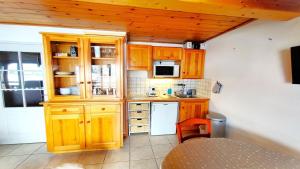 a kitchen with wooden cabinets and a white refrigerator at Résidence Les Queyrettes - Agréable Appartement Traversant 6 Personnes avec Balcon MAE-4354 in Puy-Saint-Vincent +8 photos