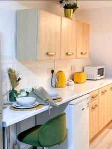a kitchen with a white counter and a green chair at City Euphoria in Portsmouth