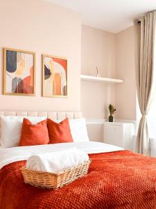 a bedroom with a bed with orange and white pillows at City Euphoria in Portsmouth