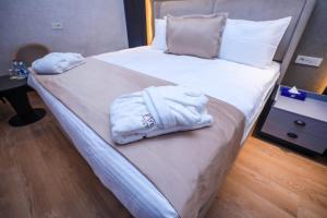 a bed with two towels sitting on top of it at Arium Hotel Baku in Baku