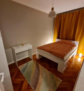 a small bedroom with a bed and a table at Campia Turzii central apartment in Cîmpia Turzii