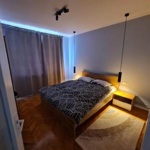 sypialnia z łóżkiem z czarno-białą kołdrą w obiekcie Campia Turzii central apartment w mieście Câmpia Turzii