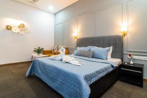 ein Schlafzimmer mit einem großen Bett mit einer blauen Decke in der Unterkunft Golf Course Suites in Gurgaon