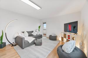 a living room with a couch and two chairs at NEU: Stylische Suite mit Ausblick in Sindelfingen
