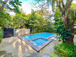 una piscina in un cortile con un albero di The Henry Resort Boracay a Boracay