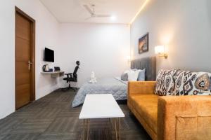 ein Wohnzimmer mit einem Sofa und einem Bett in der Unterkunft Golf Course Suites in Gurgaon