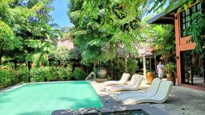 a swimming pool with lounge chairs and a swimming pool at The Henry Resort Boracay in Boracay