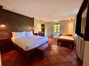 ボラカイにあるThe Henry Resort Boracayのベッドと椅子付きのホテルルーム