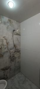 baño con aseo y pared de piedra en Ganja house en Ganja