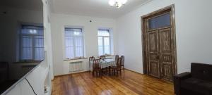 a living room with a table and chairs and a door at Ganja house in Ganja