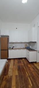uma cozinha vazia com armários brancos e pisos de madeira em Ganja house em Ganja