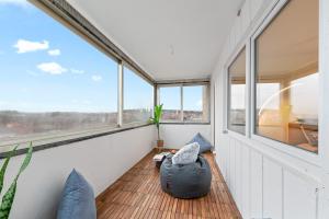 a room with windows and a couch on a wooden floor at Business & Relax Suite - Panorama - 2 Schlafzimmer - Parkplatz in Sindelfingen